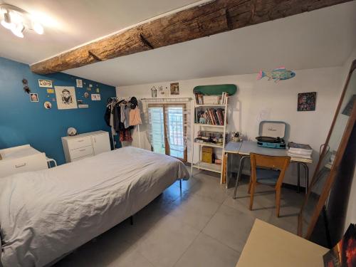 une chambre avec un lit, un bureau et une table dans l'établissement appartement de charme, à Bessan