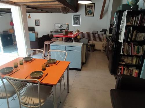 - une salle à manger avec une table et des chaises orange dans l'établissement appartement de charme, à Bessan