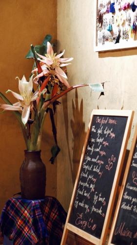 a vase filled with flowers sitting next to a sign at Maison de Hill Home in Dồng Văn