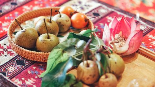 a bunch of fruit in a basket on a table at Maison de Hill Home in Dồng Văn
