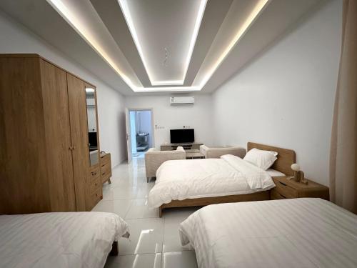 a hotel room with two beds and a television at يملا Yamla in Al Madinah