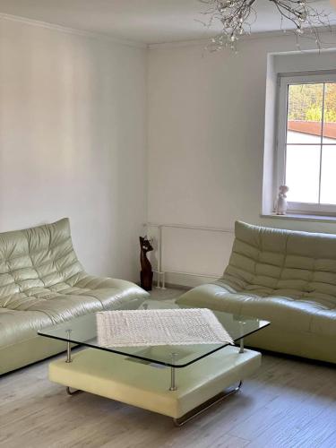a living room with two couches and a glass coffee table at Apartman Maxim N9 in Kežmarok