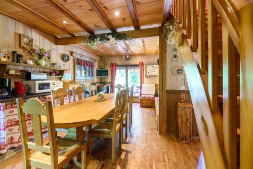 une cuisine et une salle à manger avec une table et des chaises en bois dans l'établissement Chalet Bruyères, à Saint-Maurice-sur-Moselle