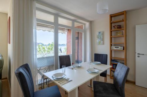 a dining room with a table and chairs and a window at Gemütliche Ferienwohnung mit Meerblick direkt am Hafen in Wilhelmshaven