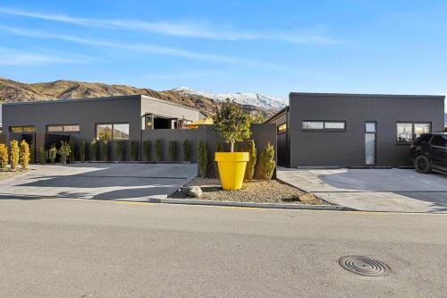 a building with a large yellow vase in front of it at Yellow Pots Apartment C, Luxurious Outdoor Bath in Wanaka