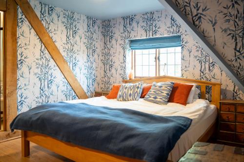 a bedroom with a bed with blue and white wallpaper at Llethrau Forest & Nature Retreats in Knighton