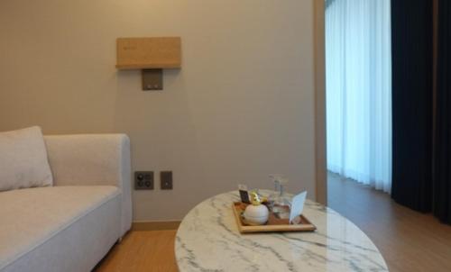 a living room with a white couch and a glass table at Elbon the stay with A1 in Busan