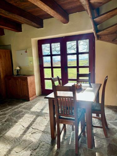 a dining room with a table and chairs and windows at Apartmány Penzion Kateřina in Nadějkov