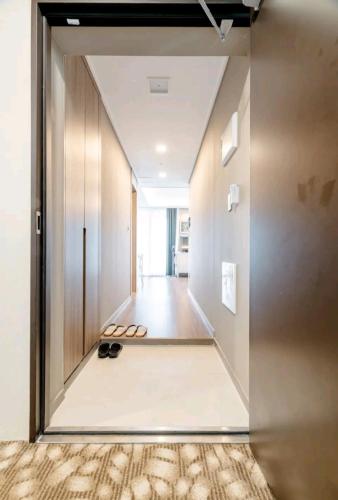 a hallway with a door and a pair of shoes at Elbon the stay with A1 in Busan