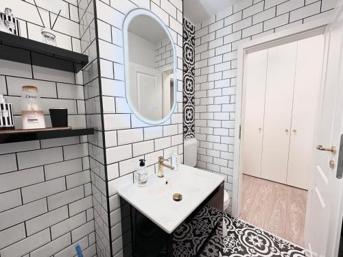 a white bathroom with a sink and a mirror at Central Spacious Apartment with Balcony - Alba Carolina in Alba Iulia