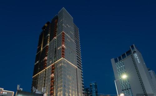 a tall skyscraper in a city at night at Elbon the stay with A1 in Busan