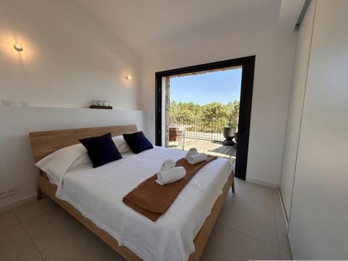 une chambre avec un grand lit avec des serviettes dessus dans l'établissement Bergerie Piana d'architecte neuve, 8 pers, piscine chauffée, à 10 min plage, à Gialla