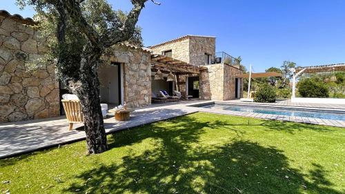 une maison avec une cour avec un arbre et une piscine dans l'établissement Bergerie Piana d'architecte neuve, 8 pers, piscine chauffée, à 10 min plage, à Gialla