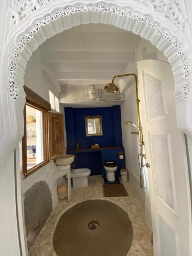 a bathroom with a toilet and a blue wall at Mill.Space in Carboneras