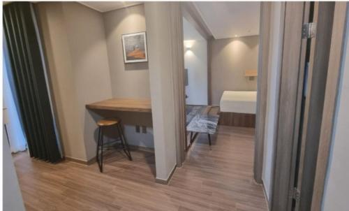 a small room with a table and a bed at Elbon the stay with A1 in Busan