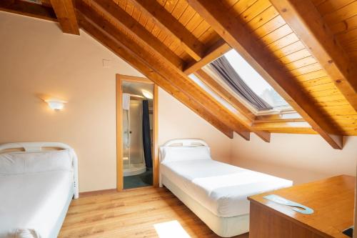sypialnia z 2 łóżkami i świetlikiem w obiekcie Hotel Alda Lalín w mieście Lalín