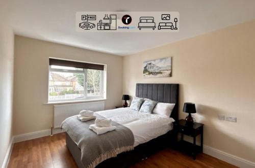 a bedroom with a large bed and a window at Modern 2 Bedroom Flat By Tara Stays Short Lets & Serviced Accommodation Watford With Free Parking & Nearby Warner Studios in Watford