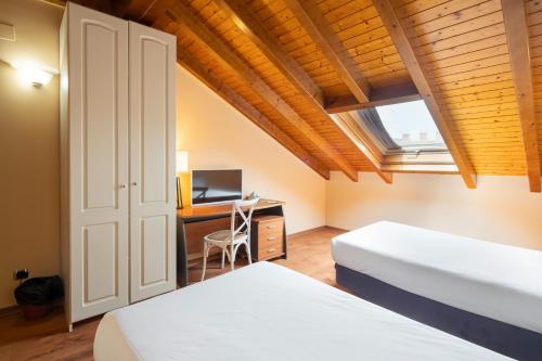2 łóżka w pokoju z biurkiem i oknem w obiekcie Hotel Alda Lalín w mieście Lalín