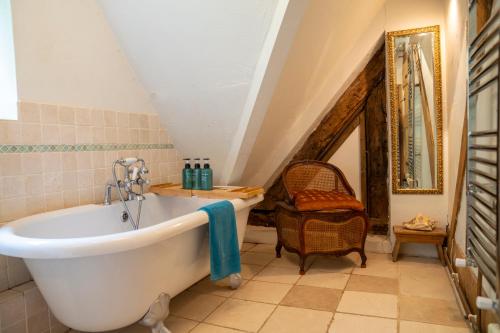 a bathroom with a large tub in a attic at Llethrau Forest & Nature Retreats in Knighton