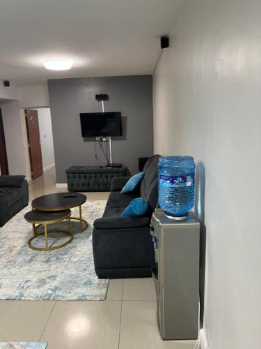 a living room with a black couch and a table at Kings place in Eldoret