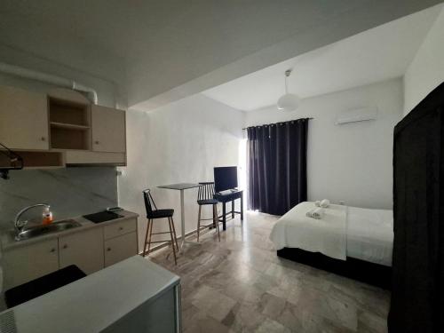 a hotel room with a bed and a table and chairs at Amalthia Hotel Apartments in Rethymno