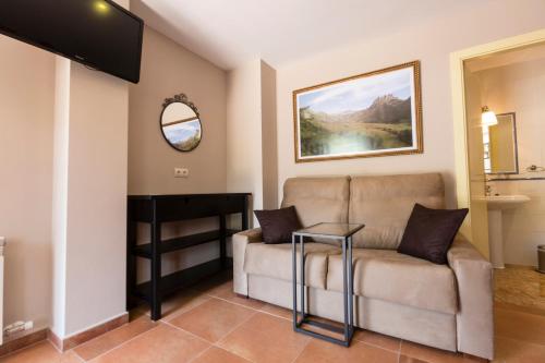 a living room with a couch and a mirror at Hotel Rural Somiedo in Valle de Lago
