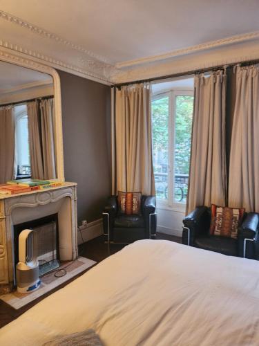 - une chambre avec un lit, une cheminée et un miroir dans l'établissement Pic de Nôtre Dame, Charming Suites Paris, à Paris