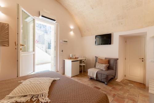 a bedroom with a bed and a couch and a window at Il Belvedere in Matera
