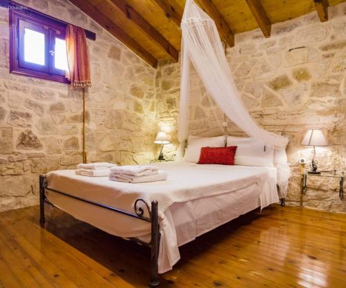 une chambre avec un lit avec moustiquaire dans l'établissement Adamantia Small Maissonette M2, à Gaios