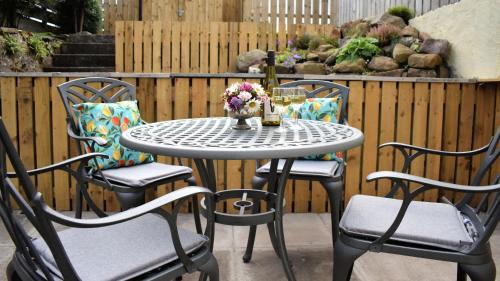 a table and chairs with flowers on a patio at Little Egret in Carsethorn