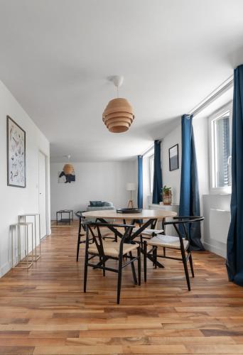 a dining room with blue curtains and a table and chairs at Résidence Léon Blum - Appartements design - Parking in Clermont-Ferrand