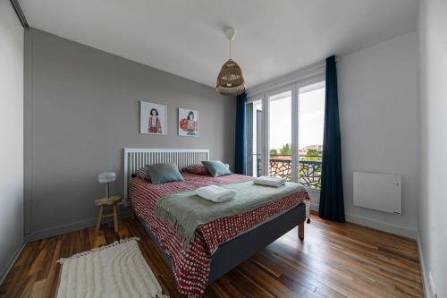 a bedroom with a bed and a large window at Résidence Léon Blum - Appartements design - Parking in Clermont-Ferrand