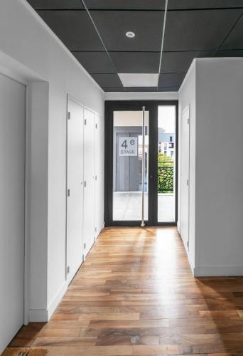 an empty corridor in an office building with a sign on the ceiling at Résidence Léon Blum - Appartements design - Parking in Clermont-Ferrand
