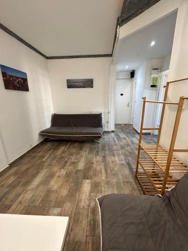 une chambre avec un canapé au milieu d'une pièce dans l'établissement 50m de la plage des catalans, à Marseille