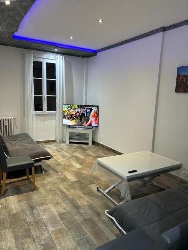 un salon avec une télévision à écran plat au mur dans l'établissement 50m de la plage des catalans, à Marseille