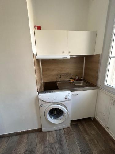 une petite cuisine avec une machine à laver et un évier dans l'établissement 50m de la plage des catalans, à Marseille
