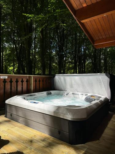 a hot tub on a deck with trees in the background at Bamboo Retreat in Louth