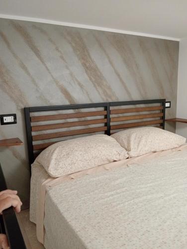two beds in a bedroom with a striped wall at Il vecchio sentiero in Acireale