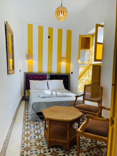 a bedroom with a bed and a table and chairs at The Madrassa Hostel in Marrakech