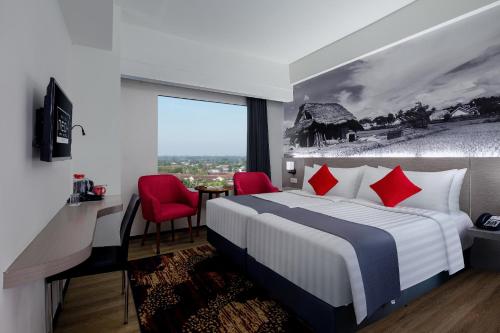 a bedroom with a large bed with red pillows at NEO+Waru-Sidoarjo by ASTON in Sidoarjo