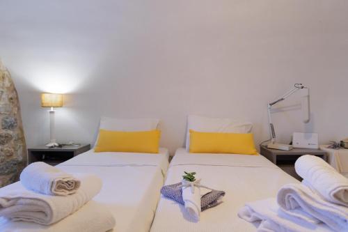 two beds in a room with towels on them at Sun Villa in Neon Oitilon