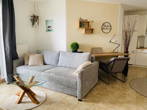 a living room with a couch and a table at Duke-Fewo am Meer im Haus Atlantic beim Kurpark in Grömitz