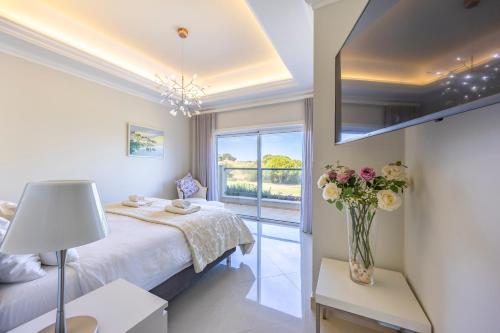 拉戈斯Boa Vista - Golf View Villa的带床和花瓶的卧室