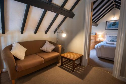 a living room with a couch and a bed at Glan Y Don Moelfre in Moelfre