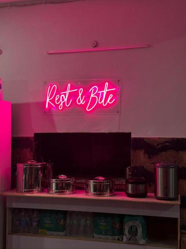 a neon sign that says rest and bite on a wall at Hotel Rest and Bite in Barkot