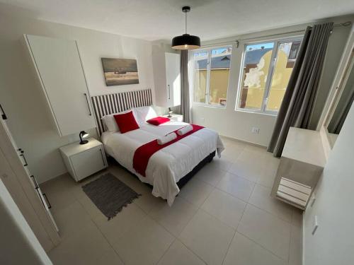 une chambre avec un grand lit avec des oreillers rouges dans l'établissement Central Apartment at Bismarck5, à Swakopmund