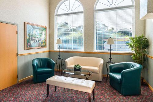 a waiting room with chairs and a table and windows at Quality Inn in Weston