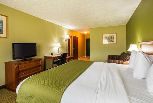a hotel room with a bed and a flat screen tv at Quality Inn in Weston