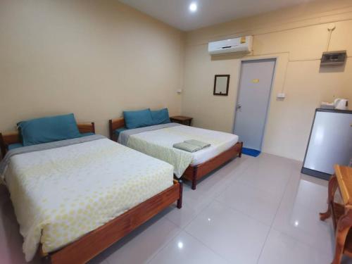 a room with two beds and a tv in it at Numhom Resort in Ban Nong Chum Saeng
