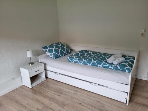a small bedroom with a white bed with blue pillows at Ferienwohnung Fink in Gallin